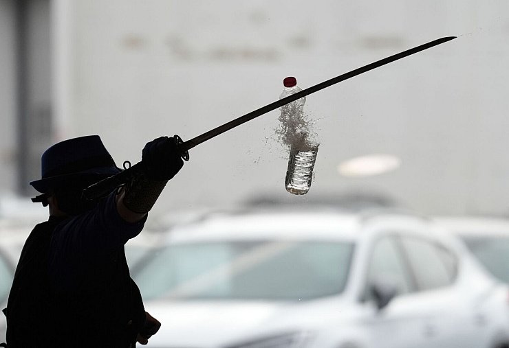 Joe Alexander zerteilt mit verbundenen Augen und einem Samurai-Schwert hochgeworfene Wasserflaschen, während des Weltrekordversuchs im Elbtor in der Hamburg Altona VW Niederlassung. Die Rekordversuche finden in Rahmen des siebzigsten Guinness World Records Day statt. - © Marcus Brandt/dpa