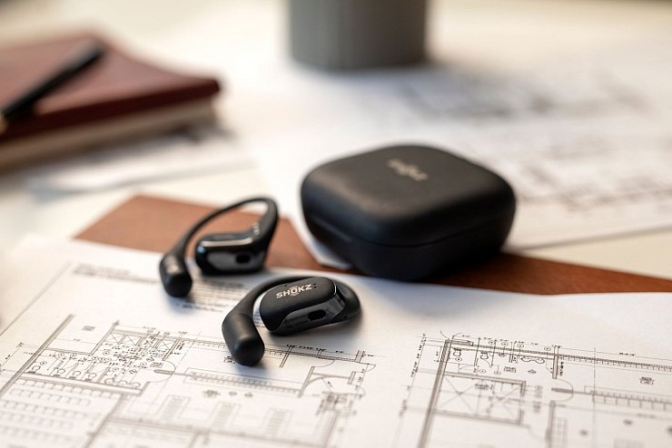 Die Shokz Openfit sind offene Kopfhörer, die vor dem Ohr getragen werden, Umgebungsgeräusche hörbar lassen und durch eine spezielle Technik den Klang gezielt ins Ohr leiten (ca. 140 Euro). - © Shokz/dpa-tmn