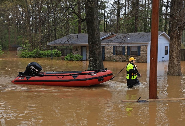 Teilweise kamen die Rettungskräfte nur noch per Boot voran. - © Colin Murphey/Arkansas Democrat-Gazette/AP/dpa