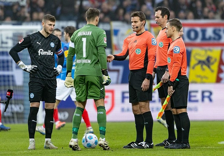 Das Schiedsrichter-Trio um Felix Brych vor dem Spiel in Kiel. - © Axel Heimken/dpa