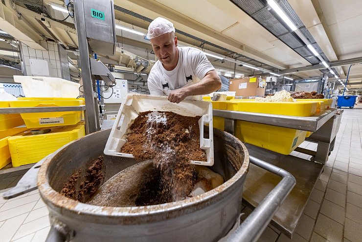 Ein Mitarbeiter des Lebkuchenherstellers Schmidt kippt in der Produktion verschiedene Rohstoffe zur Herstellung von Lebkuchenmasse in einen Behälter. - © Daniel Karmann/dpa