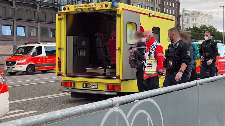Einsatzkräfte mit Mundschutz begleiten zwei Menschen zum Rettungswagen der Feuerwehr vor dem Hauptbahnhof. - © André Lenthe/Lenthe Medien/dpa