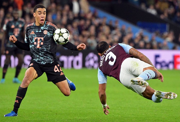 Jamal Musiala (l), hier im Einsatz gegen Aston Villa, fehlt den Bayern in Frankfurt. - © Peter Kneffel/dpa