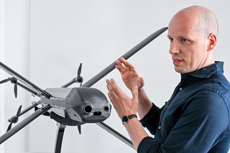 Ein Modell der HX-2-Drohne von Helsing, daneben der Mitgründer und Co-Firmenchef Gundbert Scherf. - © Jens Kalaene/dpa