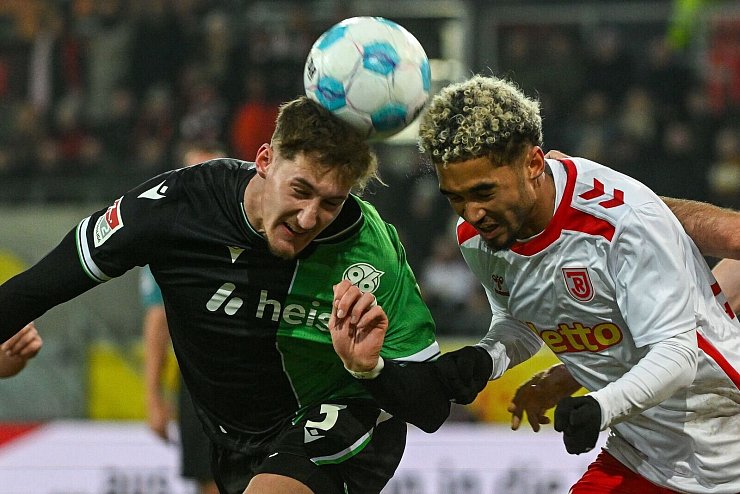 Rasantes Kopfballduell zwischen Hannovers Phil Neumann (l) und Jahn-Profi Bryan Hein. - © Armin Weigel/dpa