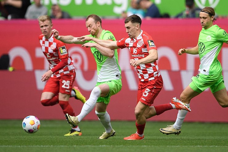Brajan Gruda (2.v.r.) von den siegreichen Mainzern im Duell mit Wolfsburgs Maximilian Arnold. - &copy; Swen Pf&ouml;rtner/dpa