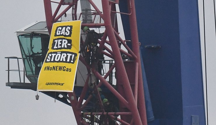 Am Verladekran im Hafen von Mukran haben Kletterer ein Banner mit der Aufschrift «Gas zerstört» befestigt. Greenpeace kritisiert, die Pipeline solle durch mehrere Meeresschutzgebiete verlaufen. - © Stefan Sauer/dpa