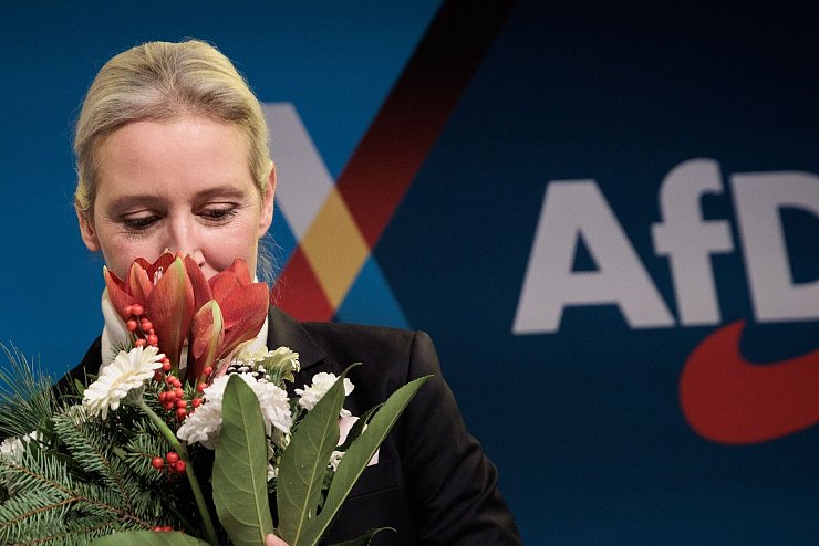 Von Co-Parteichef Tino Chrupalla gab es Blumen. Er tritt für den Wahlkampf einen Schritt zurück. - © Carsten Koall/dpa
