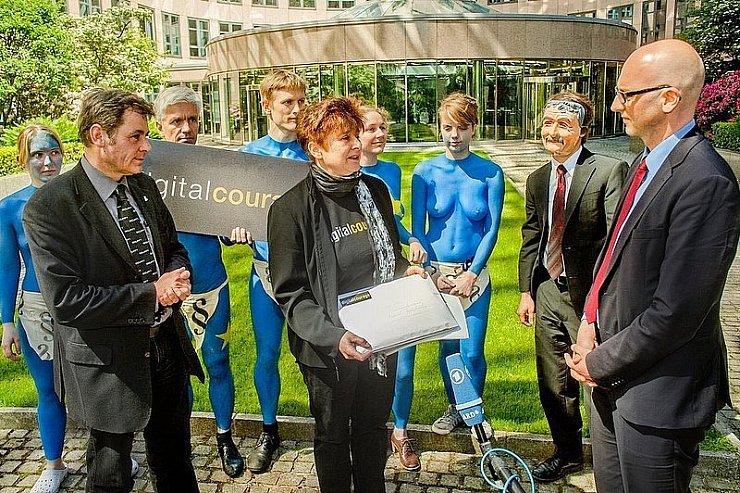 Die Bürgerrechtler Padeluun und Rena Tangens übergeben Regierungsdirektor Rainer Stenzel (r.) Post für den Innenminister.