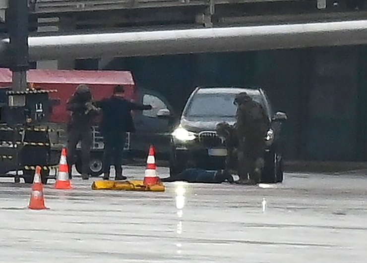 Ein Mann liegt am Hamburger Flughafen umringt von Polizeikräften auf dem Boden. - © Jonas Walzberg/dpa