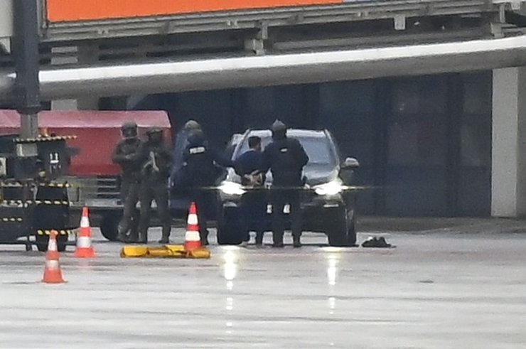 Ein Mann wird auf dem Hamburger Flughafen von der Polizei weggeführt. 18 Stunden hatte er seine vierjährige Tochter in seiner Gewalt, bevor er verhaftet werden konnte. - © Jonas Walzberg/dpa