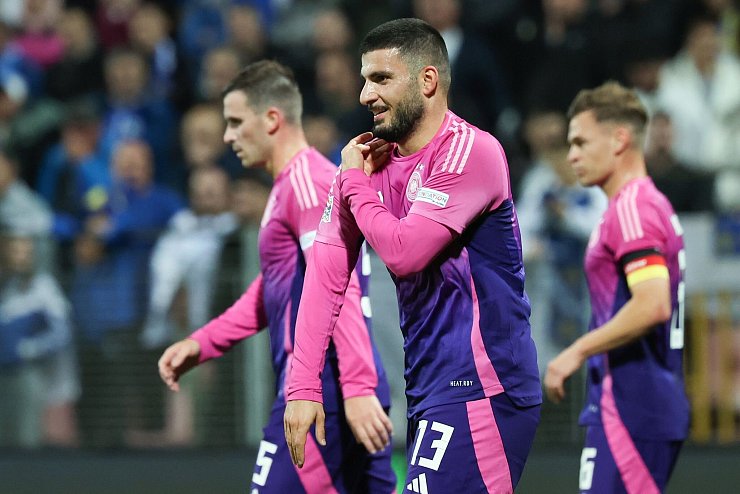 Deniz Undav (M) imitiert nach dem 2:0 die Jubelpose seines Stuttgarter Kollegen Ermedin Demirovic. Er streicht sich mit der Hand an der Schulter das Trikot glatt. - © Christian Charisius/dpa
