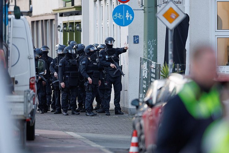 Nach Schüssen in der Nähe des Landgerichts Bielefeld sichern schwerbewaffnete Polizisten eine Straße. (Archivbild) - © Friso Gentsch/dpa