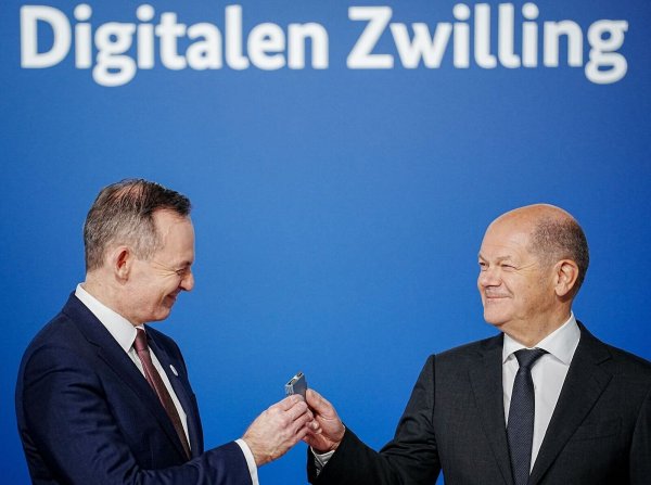 Bundeskanzler Olaf Scholz (r, SPD) übergibt an Volker Wissing (FDP), Bundesminister für Verkehr und Digitales, eine Komponente eines Schaltschranks weiter. - © Kay Nietfeld/dpa