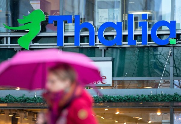 Eine Passantin geht an einer Filiale von Thalia vorbei. - © Monika Skolimowska/zb/dpa/Symbolbild