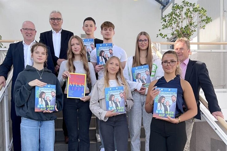IHK-Abteilungsleiter Martin Raithel, IHK-Präsident Volker Steinbach (von links) und Schulleiter Dr. Jörg Weber (rechts) stellen zusammen mit Schülerinnen und Schülern des Wirtschaftsgymnasiums am Dietrich-Bonhoeffer-Berufskollegs in Detmold den neuen Ausbildungsatlas OWL vor. Foto: IHK Lippe - © IHK Lippe