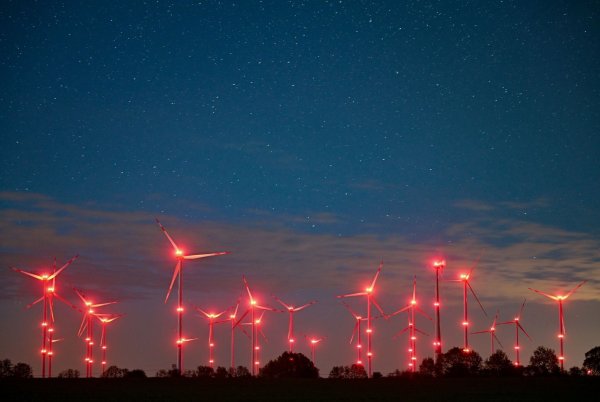 Die Positionslichter an Windenergieanlagen erhellen den Nachthimmel und die Landschaft. - © Patrick Pleul/dpa/Symbolbild
