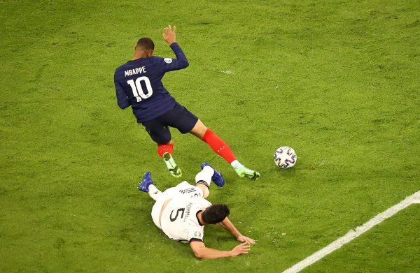 Mats Hummels nimmt Kylian Mbappé bei der EM 2021 mit einer Grätsche den Ball ab. - © Christian Charisius/dpa