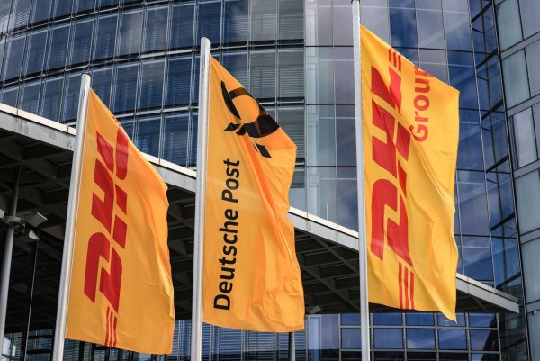Fahnen wehen vor der Zentrale der DHL Group in Bonn. - © Oliver Berg/dpa