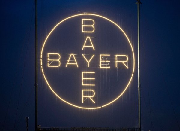 Das Bayer Kreuz, das Logo des Unternehmens, leuchtet auf dem Werksgelände von Bayer in Leverkusen. - © Thomas Banneyer/dpa