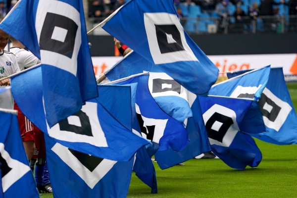 HSV-Fahnen werden vor dem Spiel auf dem Feld geschwenkt. Beim Spiel gegen Schalke wird es vermutlich keine Gäste-Choreografie geben. - © Marcus Brandt/dpa