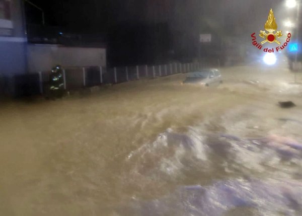 Auf einer überfluteten Straße treibt ein Auto in Kalabrien durch die Wassermassen. - © Vigili del Fuoco/dpa