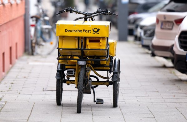 Ein Fahrrad eines Briefträgers steht auf einem Gehweg - auch dieser Briefträger möchte vermutlich gern deutlich besser bezahlt werden. - © Sven Hoppe/dpa
