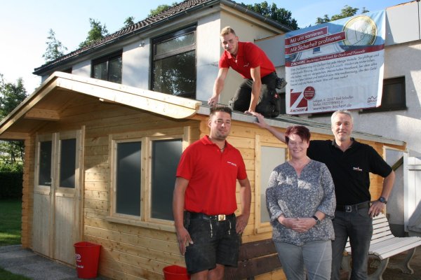 Freuen sich über den neuen Kiosk: Dachdeckermeister Thomas Zachert (rechts) mit seinen Mitarbeitern
Nico Dreher und Jan-Niklas Keeb sowie Anja Holthusen-Henriques (von
links) vom „Pfützen"-Team. - © Foto: Privat