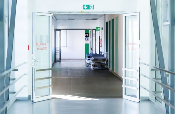 Krankenbetten stehen in einem Gang in einem Krankenhaus. - © Lukas Barth/dpa/Symbolbild
