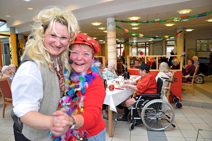 Dagmar Stock (r.) wagt mit der bunten Feder-Boa um den Hals ein Tänzchen mit Michaela Tyzack vom begleitenden Dienst. Mit blonder Perücke mimt sie den Dirigenten. - © FOTO: KARIN PRIGNITZ