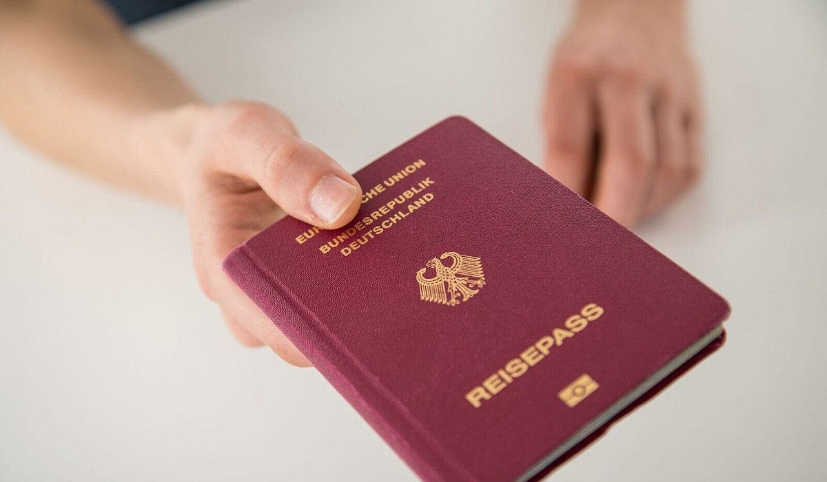 Ein junger Mann h&auml;lt seinen Reisepass in der Hand - Christin Klose/dpa-tmn
