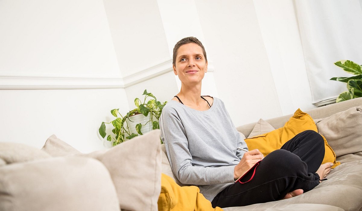 Eine Frau sitzt auf einem Sofa - Christin Klose/dpa-tmn