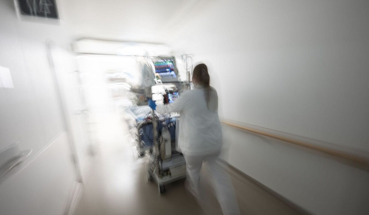 Pflegerin f&auml;hrt eine Intensivpatientin durch denGang einer Klinik - Marijan Murat/dpa/dpa-tmn