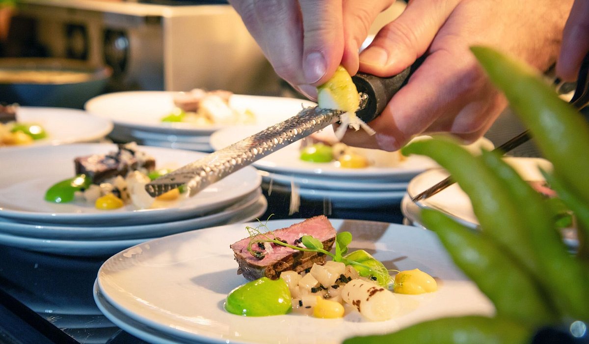 Koch reibt Zesten der Zitrusfrucht Buddhas Hand &uuml;ber ein Men&uuml; - Christin Klose/dpa-tmn