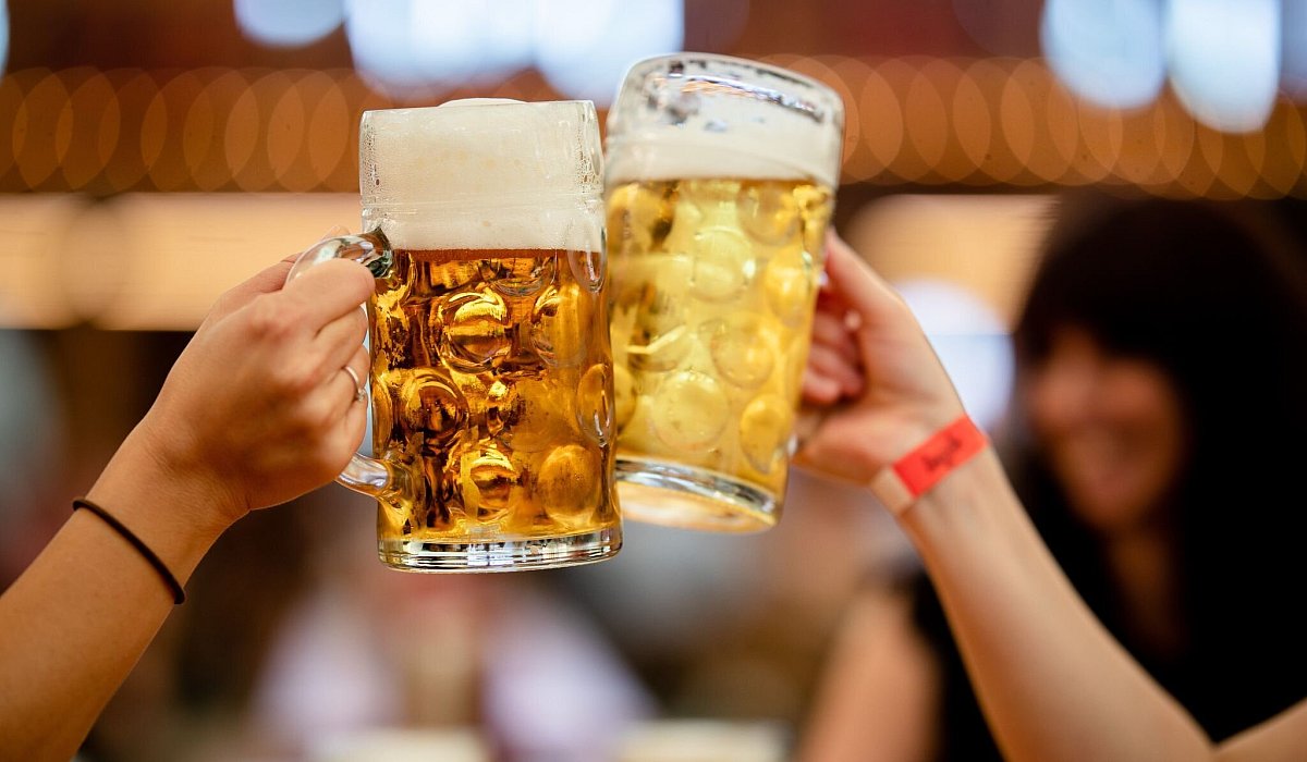 Besucher des Stuttgarter Frühlingsfests stossen mit 2 Maß Bier an - Christoph Schmidt/dpa/dpa-tmn