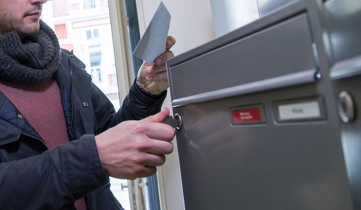Ein Mann holt einen Brief aus dem Briefkasten - Christin Klose/dpa-tmn