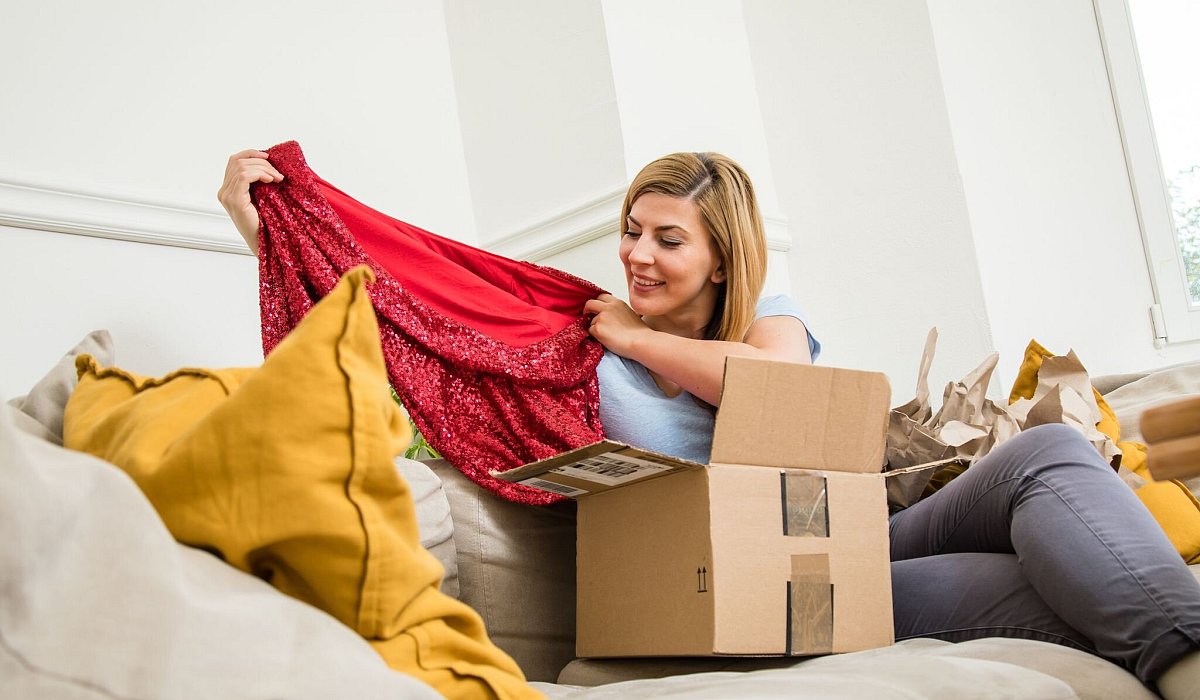 Eine Frau packt Klamotten aus - Christin Klose/dpa-tmn