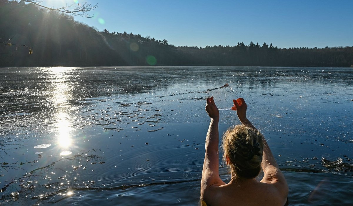 Frau geht in einem Loch im Eis baden - Patrick Pleul/dpa/dpa-tmn