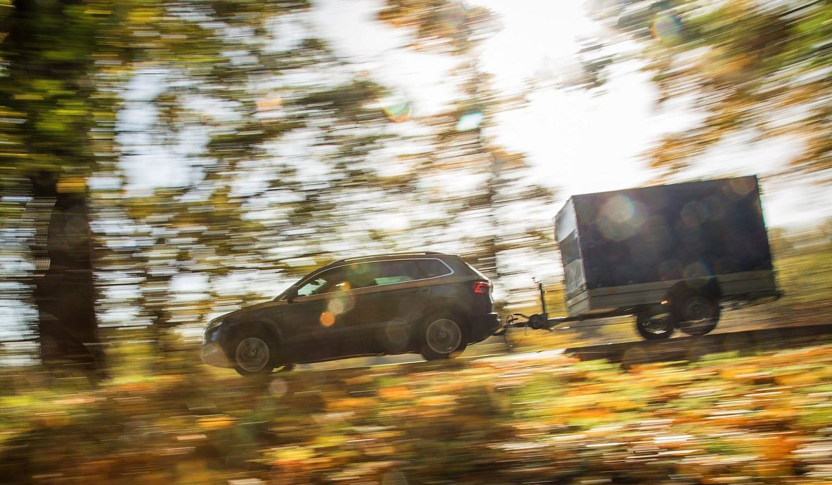 Ein Auto mit Anhänger fährt die Straße entlang - Christin Klose/dpa-tmn