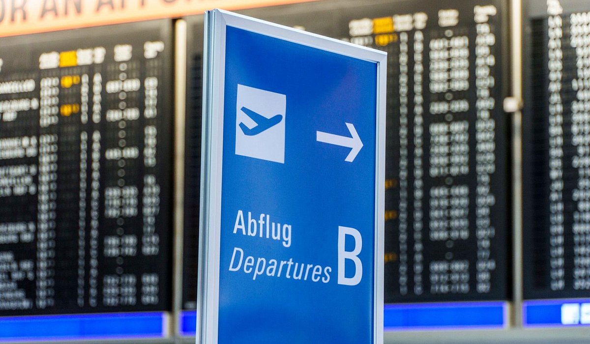 Ein Hinweisschild &laquo;Abflug&raquo; steht vor der grossen Anzeigetafel - Andreas Arnold/dpa/dpa-tmn