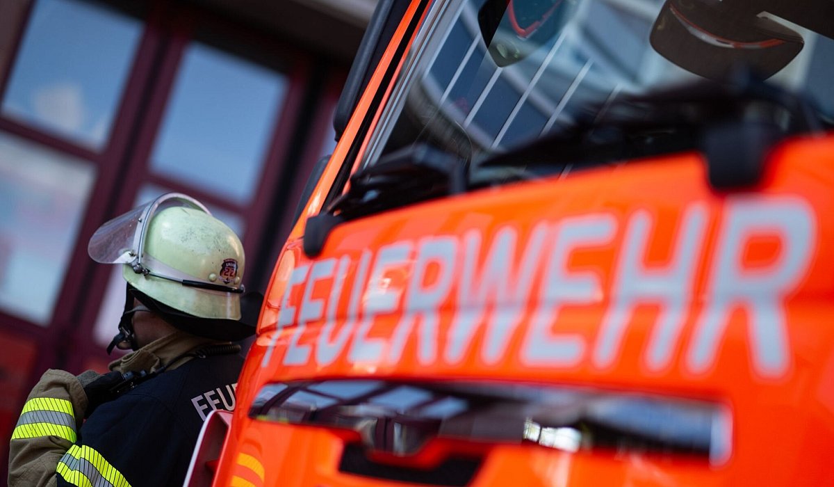 Feuerwehrmann neben einem Feuerwehrauto - Marijan Murat/dpa