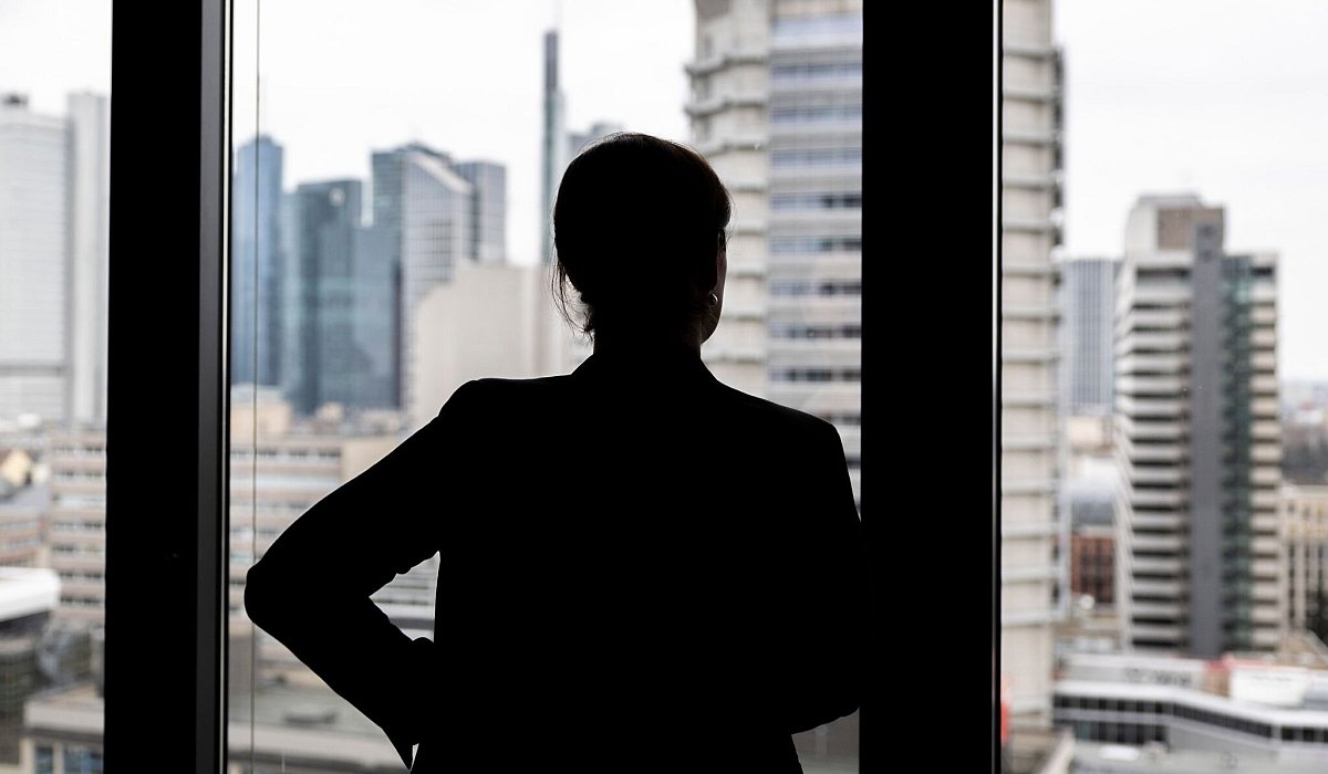 Frau schaut aus einem Bürofenster - Hannes P Albert/dpa/dpa-tmn