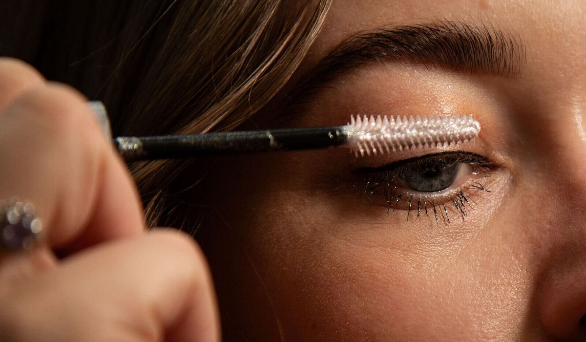 Frau tuscht sich die Wimpern mit Glitzer-Mascara - Christin Klose/dpa-tmn