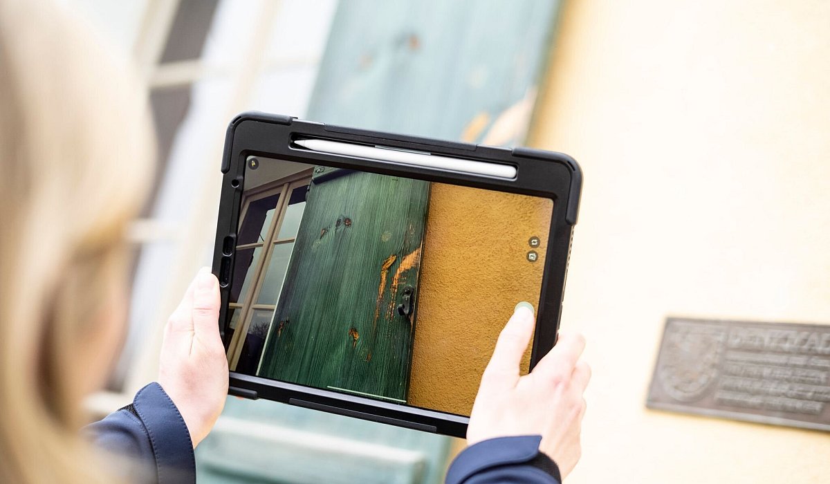 Eine Frau dokumentiert mit ihrem Tablet Sch&auml;den an einem Haus - Alexander Prautzsch/dpa-tmn