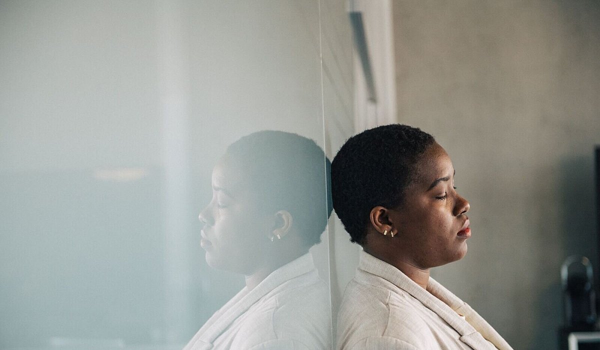 Eine junge Frau lehnt nachdenklich an einer Glaswand - Zacharie Scheurer/dpa-tmn