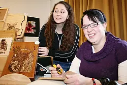 Handgemachte Eleganz: Bianca Küpper (rechts) und Ina Richter setzen mit Brandmalerei Akzente. - © FOTO: CASTRUP