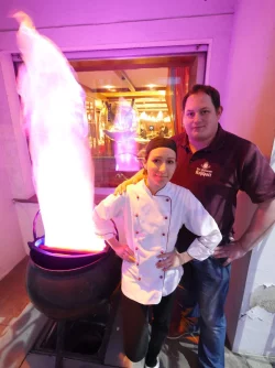 Starkes Team: Die neue Pächterin Margerita Ortega steht mit ihrem Partner Daniel Kohring am neu beleuchteten Kohlpott vor dem Gebäude. Das Fenster gewährt einen Blick in die Gaststube. - © Jost Wolf