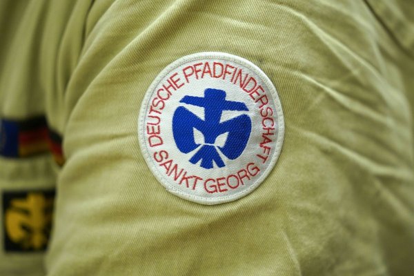 Ein Pfadfinder der Deutschen Pfadfinderschaft Sankt Georg (DPSG) sitzt während der Übergabe des Friedenslichts aus Bethlehem im Generalkonsulat der Ukraine. - © Marcus Brandt/dpa