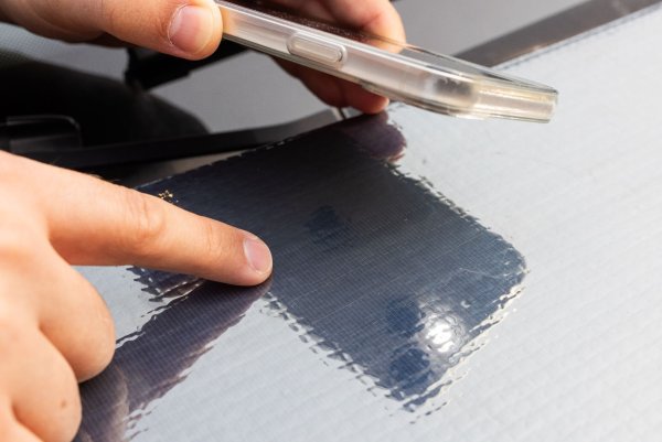 Ein Forscher des Fraunhofer ISE zeigt auf die Struktur der Solarzellen auf einer Motorhaube. - © Philipp von Ditfurth/dpa