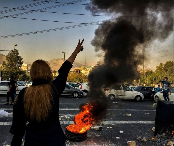 Eine Frau steht während einer Demonstration nach dem Tod der 22-jährigen Mahsa Amini Ende September in der iranischen Hauptstadt und zeigt das Victory-Zeichen. - © Uncredited/AP/dpa